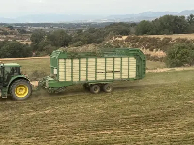 Tractor con remolque autocargador recogiendo forraje verde